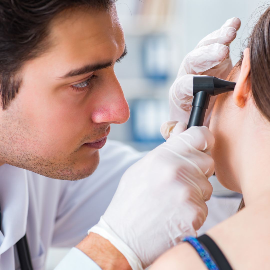 an otolaryngologist looking in a woman's ear