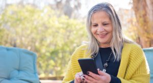 an older woman smiling at her phone