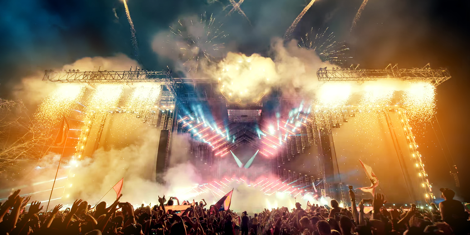 Crowd at concert and blurred stage lights with fireworks