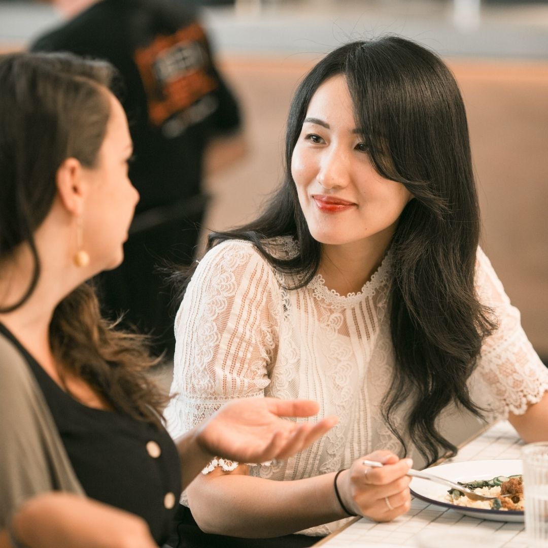 woman enjoying dinner with a friend after hearing loss solutions