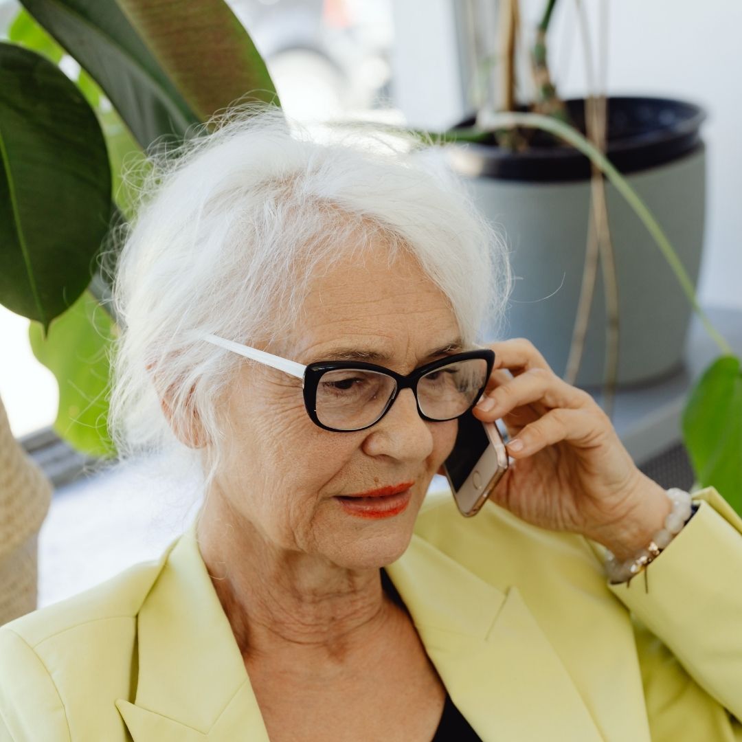 elderly woman struggling to hear on the phone